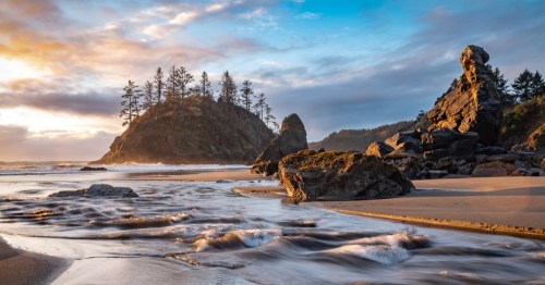 A beach in Trinidad California at sunset, with color streaking across the sky and highlighting the rocks in the ocean.