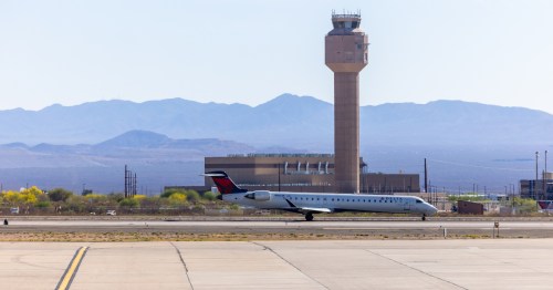 an airplane sits on the runway in front of the air traffic control tower at tucson international airport (TUC) in Arizona